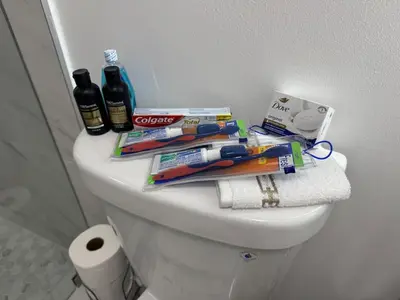 a white toilet with toothbrushes toothpaste and other items on it at Modern Apartment Miami Oasis in Miami