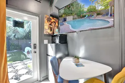 a caravan with a table and a swimming pool at Kiki 4 - Men's Clothing optional Guest Houses in Fort Lauderdale