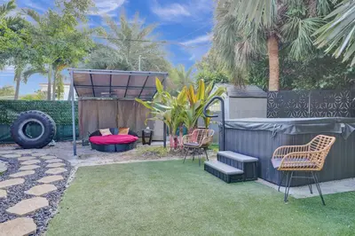 a backyard with two chairs and a bed and a fence at Kiki 4 - Men's Clothing optional Guest Houses in Fort Lauderdale