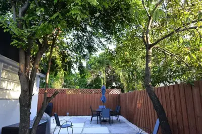 a patio with tables and chairs and a fence at Fab 4BR Twin Villas Near Design District and Wynwood in Miami