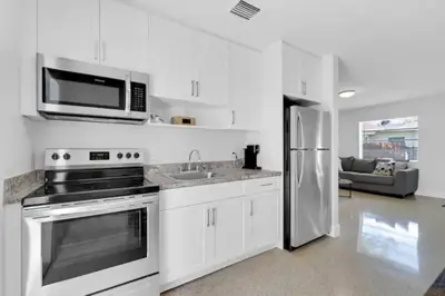 a kitchen with white cabinets and a stainless steel refrigerator at Fab 4BR Twin Villas Near Design District and Wynwood in Miami