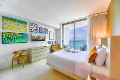 a bedroom with a bed and a desk and a window at Sun and Beach Closer of You! Condo All-In in Hollywood