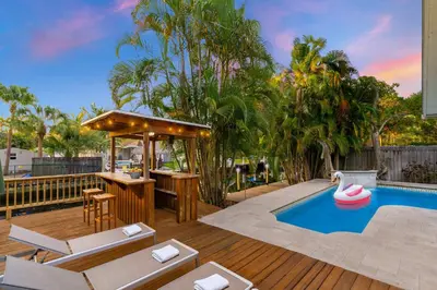 a backyard with a pool with a bar and a swimming pool at Waterfront House - Solar Heated Pool, Arcade Games in Fort Lauderdale