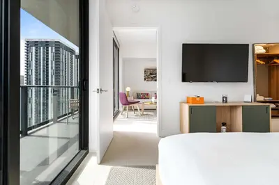 a bedroom with a bed and a view of a living room at RumRunner - Hotel style amenities in the heart of Miami in Miami