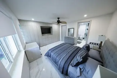 a bedroom with a bed and a flat screen tv at New! Upscale Modern waterfront apartment 3BR 3BA in Miami