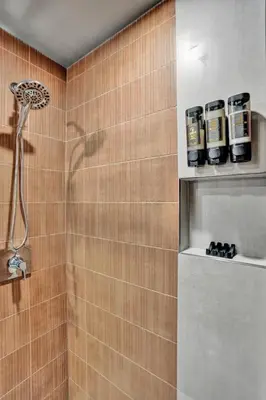 a bathroom with a shower with two bottles on a shelf at Kiki 5 - Men's Clothing optional Guest Houses in Fort Lauderdale