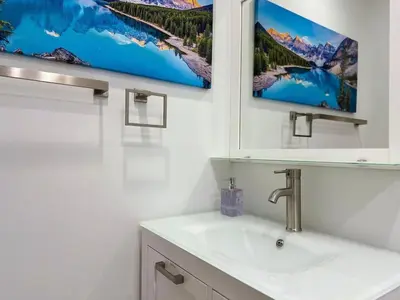 a bathroom with a sink and two pictures on the wall at Relaxing Retreat 2BR Oasis with Pool and Outdoor BBQ in Pembroke Pines