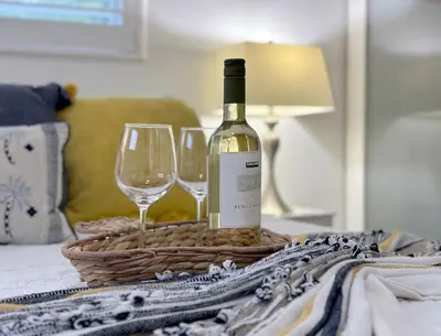 a bottle of wine and two wine glasses on a bed at Relaxing Retreat 2BR Oasis with Pool and Outdoor BBQ in Pembroke Pines