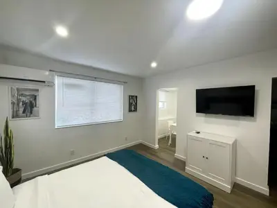 a bedroom with a bed and a flat screen tv at Tranquil Studio W Parking 10 min to Beach FLL in Hollywood