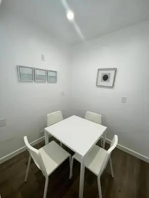 a white table and chairs in a white room at Tranquil Studio W Parking 10 min to Beach FLL in Hollywood