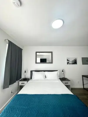 a bedroom with a large bed with a blue blanket at Modern Studio W Parking 10 min to FLL and Beach in Hollywood