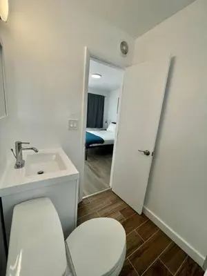 a bathroom with a white toilet and a sink at Modern Studio W Parking 10 min to FLL and Beach in Hollywood