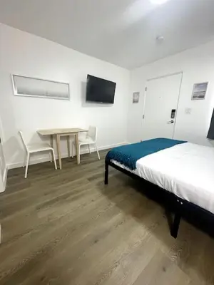 a bedroom with a bed and a table with chairs at Modern Studio W Parking 10 min to FLL and Beach in Hollywood