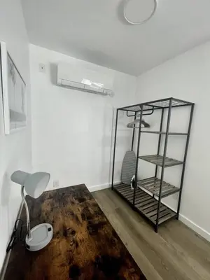 a room with a desk with a lamp and a shelf at Modern Studio W Parking 10 min to FLL and Beach in Hollywood
