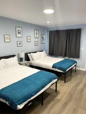 two beds in a room with blue walls at Las Olas Studio W Parking 10 min to FLL and beach in Hollywood