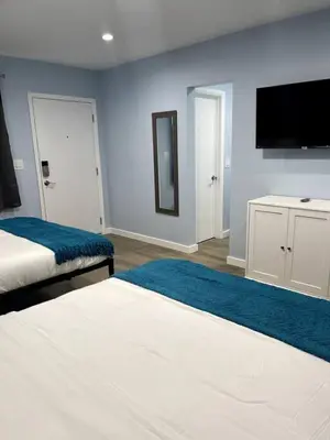a bedroom with two beds and a flat screen tv at Las Olas Studio W Parking 10 min to FLL and beach in Hollywood