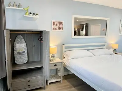 a bedroom with a bed and a mirror at Serene Studio W Parking 10 min from Beach and FLL in Hollywood