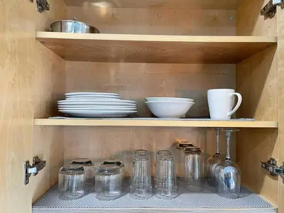 a shelf with glass jars and plates on it at Serene Studio W Parking 10 min from Beach and FLL in Hollywood