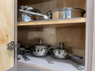a shelf with pots and pans in a kitchen at Serene Studio W Parking 10 min from Beach and FLL in Hollywood