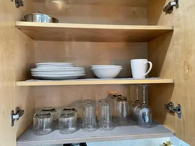 a shelf with glass jars and plates on it at Serene Studio W Parking 10 min from Beach and FLL in Hollywood
