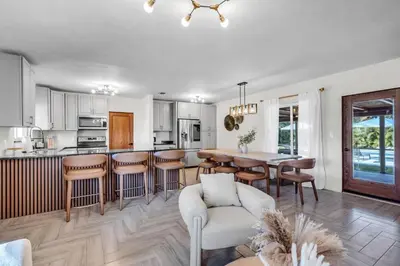 a kitchen and living room with a table and chairs at Pickleball fun Family home near Hard Rock Stadium in North Miami