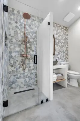 a shower with a glass door in a bathroom at Pickleball fun Family home near Hard Rock Stadium in North Miami