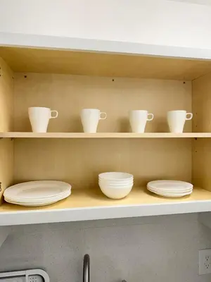 a kitchen shelf with plates and cups on it at Apartament Miami Design District in Miami