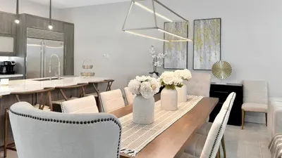 a dining room with a table with white flowers in vases at Lux 4BR Retreat with Heated Pool, BBQ, and Bikes in Miami