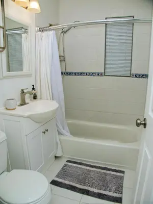 a bathroom with a white tub and a sink and a toilet at Welcome to Miami Springs Charm in Miami