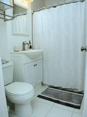 a white bathroom with a toilet and a sink at Welcome to Miami Springs Charm in Miami