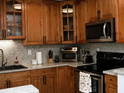 a kitchen with wooden cabinets and stainless steel appliances at Welcome to Miami Springs Charm in Miami