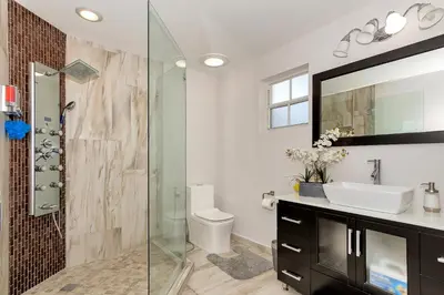 a bathroom with a glass shower and a sink at Tropical house Miami in Cutler Bay