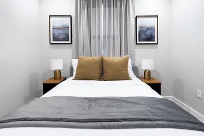 a bedroom with a large white bed with two lamps at Prestige Brickell Miami Suite in Miami