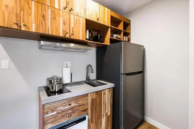 a kitchen with a stainless steel refrigerator and wooden cabinets at Prestige Brickell Miami Suite in Miami