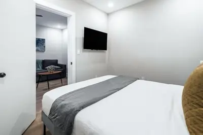 a bedroom with a bed and a tv on the wall at Prestige Brickell Miami Suite in Miami