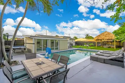 a patio with a table and chairs next to a swimming pool at Cozy Miami Private Pool House W- Arcade Games, BBQ in Norland