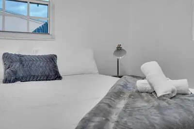 a white bedroom with a bed with towels on it at Cozy Miami Private Pool House W- Arcade Games, BBQ in Norland