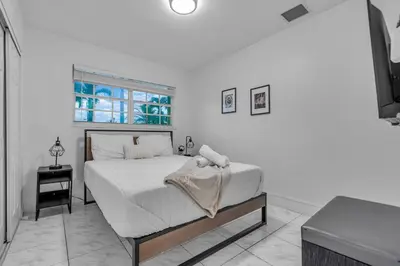 a white bedroom with a bed and a window at Cozy Miami Private Pool House W- Arcade Games, BBQ in Norland