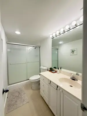 a bathroom with a toilet and a sink and a mirror at 1 SPRING PROMO - Sunny Isles Seaview Condo, Walk to Beach, Amazing Amenities in Sunny Isles Beach