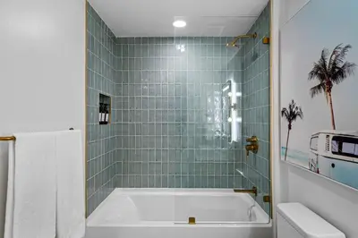 a bath tub in a bathroom with green tiles at 37th Floor - 1bdrm Unt amazing View at Downtown Miami in Miami