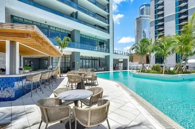 a swimming pool with tables and chairs next to a building at Great Studio Pool Gym & Views in Miami