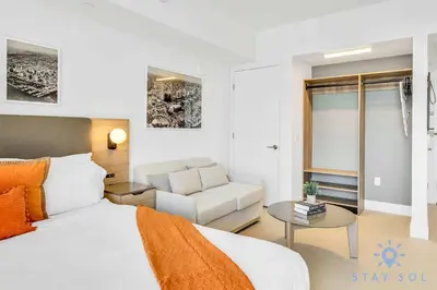 a bedroom with a bed and a chair and a couch at Lovely Studio - Pool & Gym in Miami