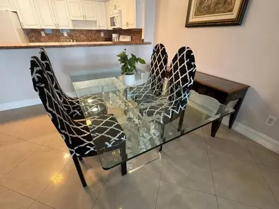 a glass table with two chairs and a table with a glass top at Luxury Ocean Reserve Condo Pool, Gym & Beach Access in Sunny Isles Beach