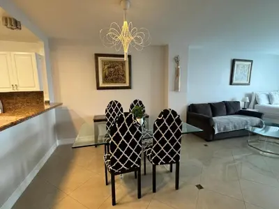a living room with a glass table and two chairs at Luxury Ocean Reserve Condo Pool, Gym & Beach Access in Sunny Isles Beach