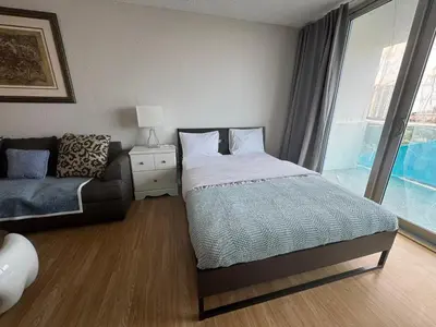 a bedroom with a bed and a couch and a window at Luxury Ocean Reserve Condo Pool, Gym & Beach Access in Sunny Isles Beach