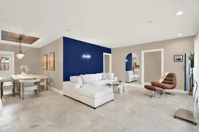 a living room with a white couch and a table at HUGE Outdoor soccer 4BR HEATED Pool house near Las Olas in Fort Lauderdale