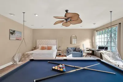a living room with a pool table and a bedroom at HUGE Outdoor soccer 4BR HEATED Pool house near Las Olas in Fort Lauderdale