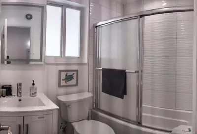a bathroom with a shower and a toilet and a sink at Charming DBL W pool and parking 15 min to FLL and Beach in Hollywood