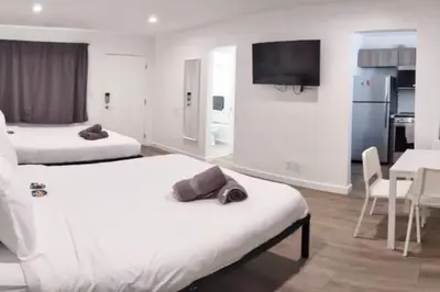 a hotel room with two beds and a dining room at Charming DBL W pool and parking 15 min to FLL and Beach in Hollywood