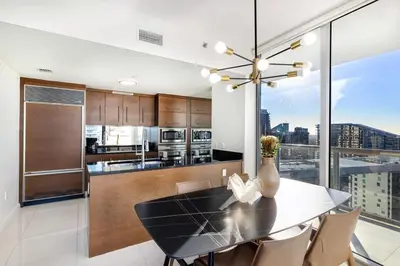 a kitchen with a dining table and a large window at Sky High Penthouse Corner 2BR 2BA Icon Brickell in Miami